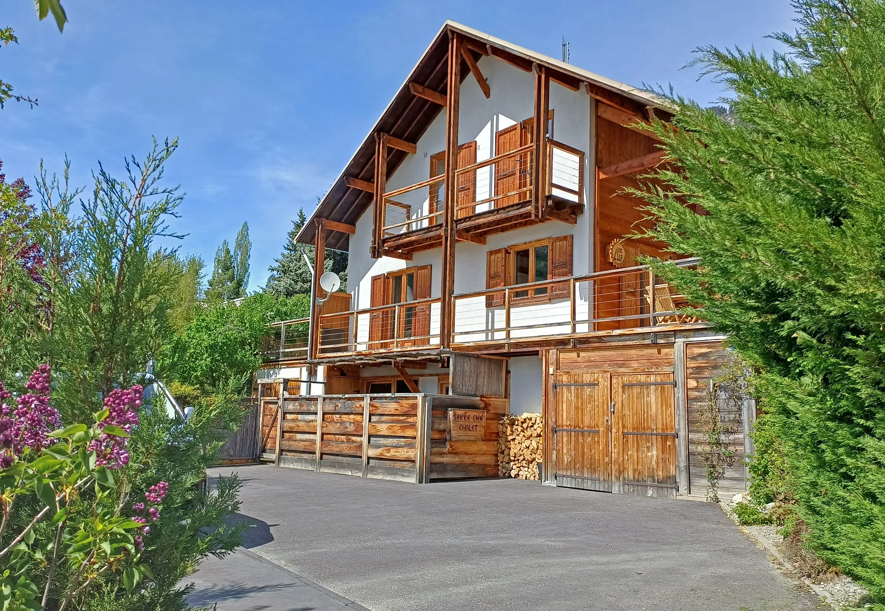The Bike-Alp chalet exterior with wooden balconies and a garden