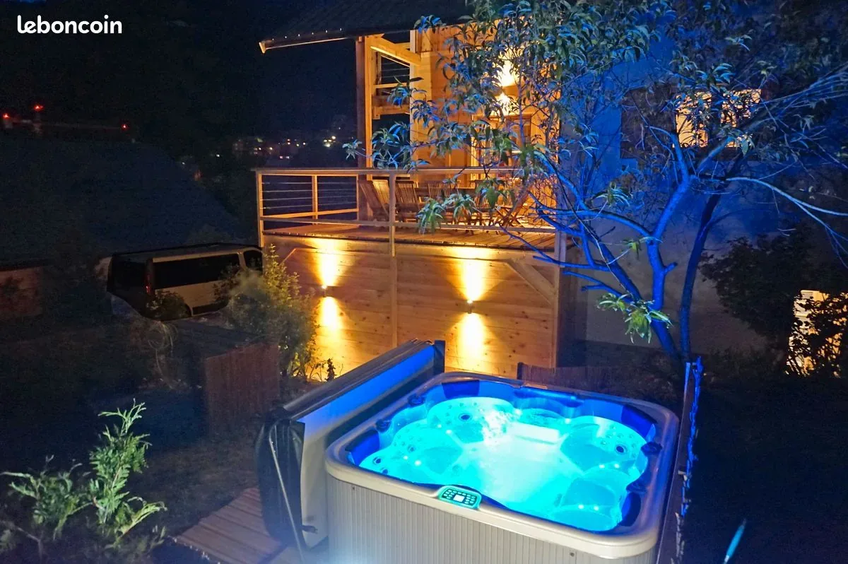 Outdoor hot tub glowing at night beside the chalet